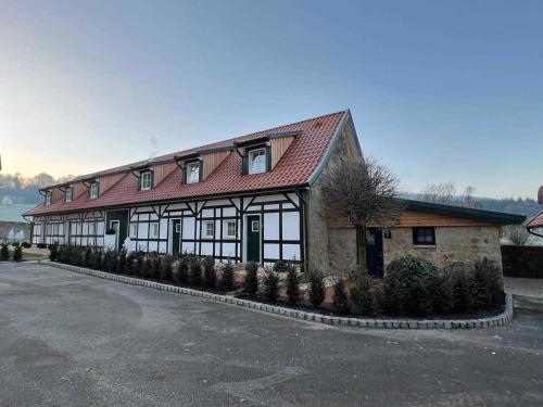 a building with a red roof and some plants at DRIEHOF LifeStyle Suite Apt 1 in Tecklenburg