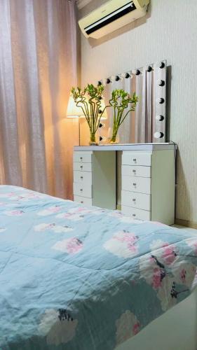 een slaapkamer met een bed en een dressoir met bloemen erop bij Dzora Vista Alam 3 in Shah Alam