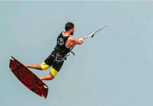 um homem numa prancha de surf agarrado a uma corda em Amazing 2 bedroom Selena Bay Hurghada em Hurghada