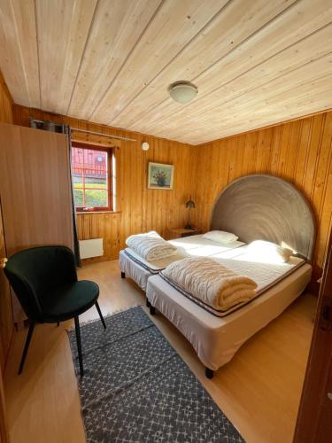 a bedroom with two beds and a chair at Torsby Camping in Torsby