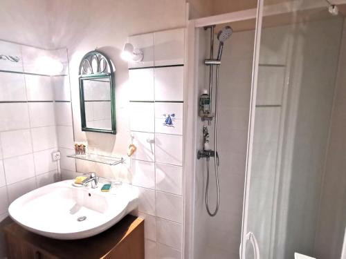 une salle de bain blanche avec un lavabo et une douche dans l'établissement Desiree Arago 400m de la Plage, à Les Sables-dʼOlonne