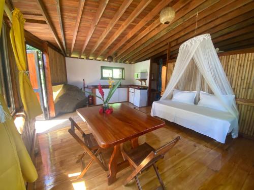 a bedroom with a bed and a table and a bed at Fare Oviri Lodge in Opoa