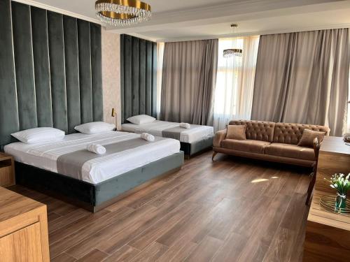 a hotel room with two beds and a couch at Tbili Metekhi Boutique Hotel in Tbilisi City