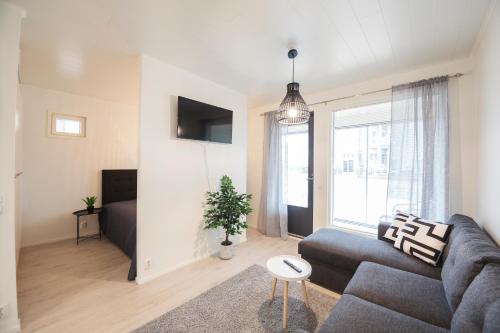 a living room with a couch and a window at Tuomenkartano Apartments by Hiekka Booking in Kalajoki