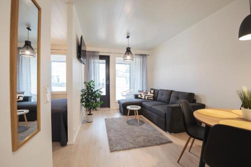 a living room with a couch and a table at Tuomenkartano Apartments by Hiekka Booking in Kalajoki