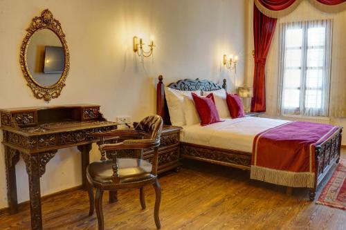a bedroom with a bed and a desk and a mirror at Four Mansions Hotel in Kayseri