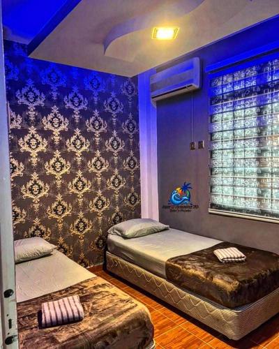 2 Einzelbetten in einem Zimmer mit blauer Beleuchtung in der Unterkunft Amy D’ Homestay Jacuzzi PD in Port Dickson