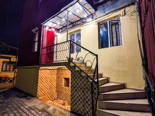 バトゥミにあるHarmony Boutique Hostelの赤い扉のある建物へと続く階段