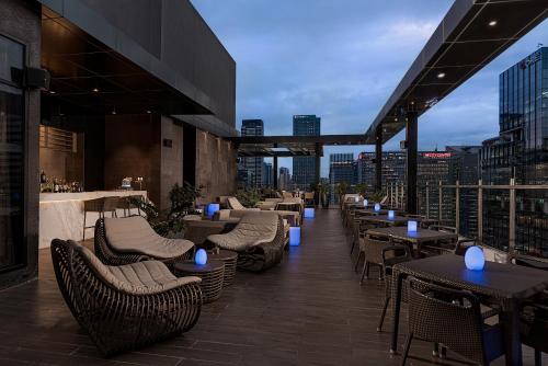 a restaurant with tables and chairs on a rooftop at Seda Bonifacio Global City in Manila