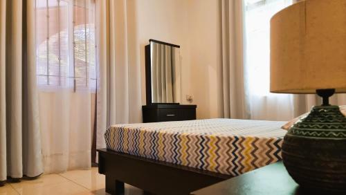 a bedroom with a bed and a lamp on a table at Villa Agata Mauritius in Mont Choisy