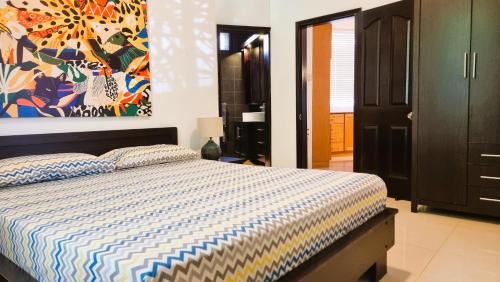a bedroom with a bed and a painting on the wall at Villa Agata Mauritius in Mont Choisy