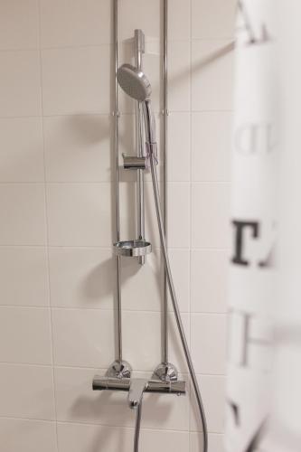 eine Dusche mit Duschkopf im Badezimmer in der Unterkunft Koivula Guest House in Kotka