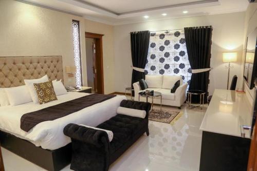 a bedroom with a large bed and a couch at Grace Boutique Hotel in Islamabad