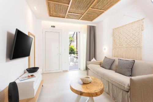 Anastasia Apartments Hanioti في هانيوتي: غرفة معيشة مع أريكة وطاولة