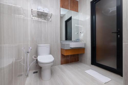 a bathroom with a toilet and a sink at Aralea Coliving in Denpasar