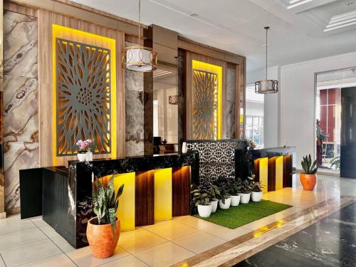 a lobby with yellow and black walls and potted plants at Ohulu Guesthouse in Medan
