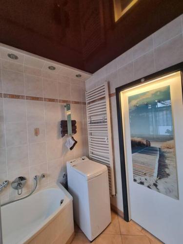 a bathroom with a tub and a toilet and a sink at Ferienwohnung *Zur Weinbergstraße* in Lauta