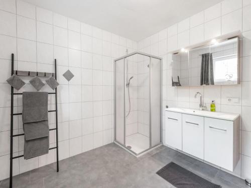 a white bathroom with a shower and a sink at Beautiful apartment in Hart im Zillertal with mountain view in Hart im Zillertal