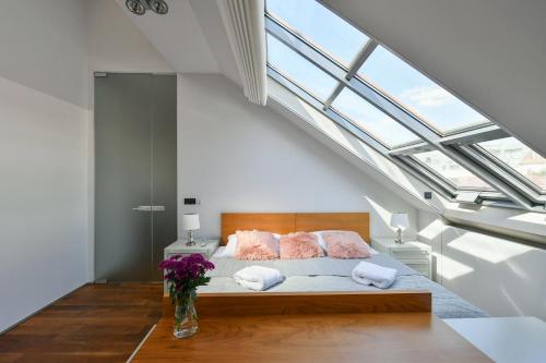 Schlafzimmer mit einem Bett und einem großen Dachfenster in der Unterkunft LUXURY CENTRAL PENTHOUSE WITH SAUNA, TERRACE, 250m2, 5BDRM, 3BTHRM in Prag