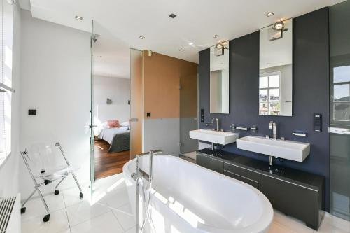 ein Badezimmer mit 2 Waschbecken und einer Badewanne in der Unterkunft LUXURY CENTRAL PENTHOUSE WITH SAUNA, TERRACE, 250m2, 5BDRM, 3BTHRM in Prag