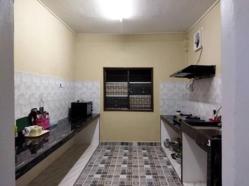 eine Küche mit einer Spüle und einer Arbeitsplatte in der Unterkunft Homestay Abi in Kota Bharu