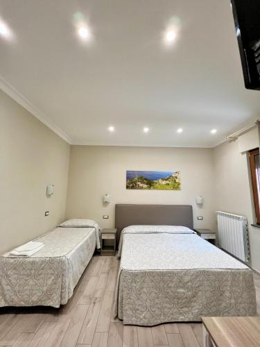 a bedroom with two beds and a tv at Relais Milò in Agerola