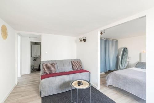 1 dormitorio con cama, sofá y mesa en Appartement 200 m plage avec terrasse et jardin, en Royan