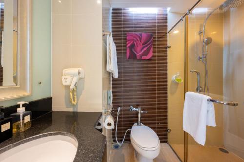 a bathroom with a toilet and a sink and a shower at Grand Richmond Stylish Convention Hotel in Nonthaburi