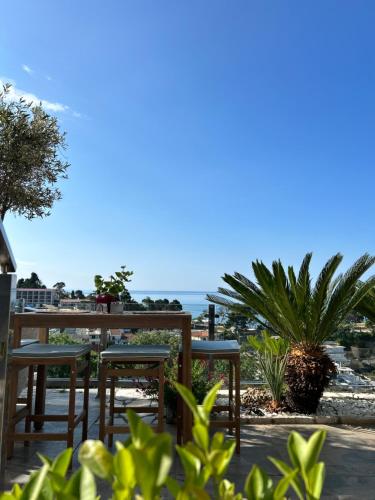 a patio with tables and chairs with the ocean in the background at Senator in Ulcinj