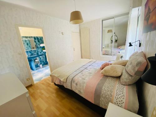 una camera da letto con letto, cuscini e specchio di Chez Maria a Pontorson