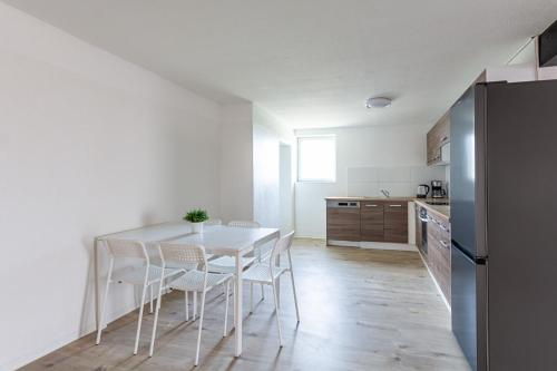 uma cozinha branca com uma mesa e cadeiras brancas em T&K Apartments Wegberg 5 Monteur Apartments em Wegberg