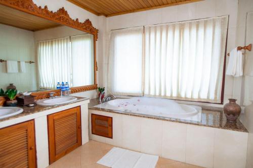 uma casa de banho com 2 lavatórios e uma grande banheira em KMA Kaytumadi Hotel em Taungoo
