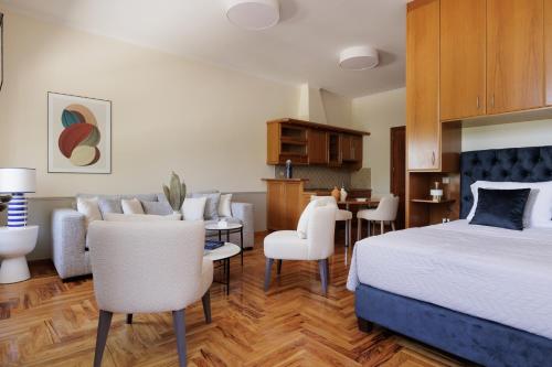 a hotel room with a bed and a dining room at LISTON'S Central Suites in Corfu Town