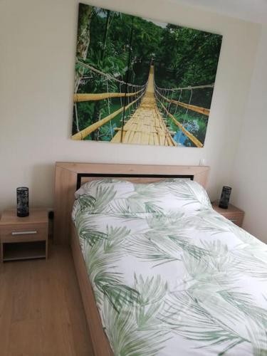 une chambre avec un lit avec un tableau sur le mur dans l'établissement Villa Paradisiaque 3 Étoiles Détente chez Suzanne, à Tilloy-Floriville