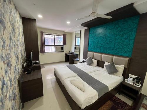 a bedroom with a large bed with a blue wall at Hotel Pratap Residency-With early check inn in Rānchī