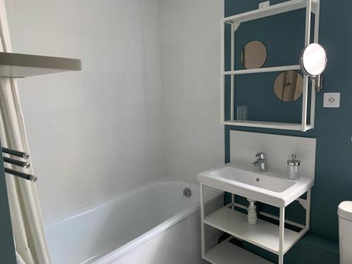 une salle de bain avec un lavabo, une baignoire et un miroir dans l'établissement LE NID SUR LA FALAISE, à Ault