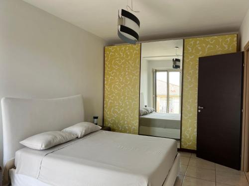 a bedroom with a white bed and a mirror at Sweet Dream in Acitrezza