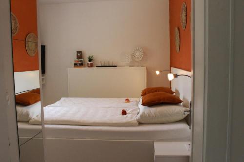 1 dormitorio con 1 cama con sábanas y almohadas blancas en Ferienbungalow Juri am Millstätter See, en Döbriach