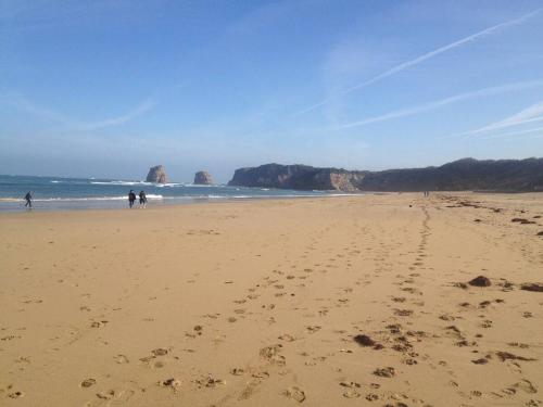 une plage avec des empreintes de pas dans le sable et des gens dessus dans l'établissement Voilier à quai 4 personnes - 2 mn à pieds grande plage, à Hendaye