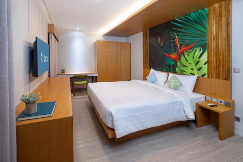 a hotel room with a bed and a painting on the wall at Aralea Coliving in Denpasar