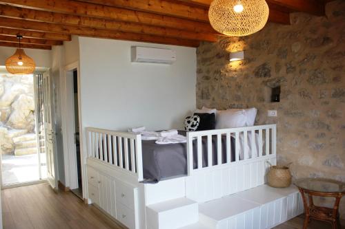 Habitación con cuna blanca con almohadas en Palma resorts en Nikiá