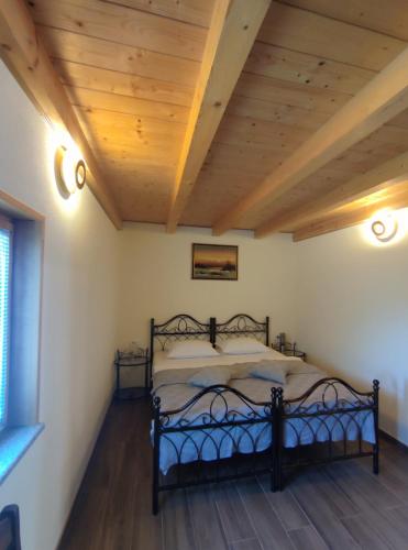 1 dormitorio con 1 cama con techo de madera en ISKRA, en Grožnjan