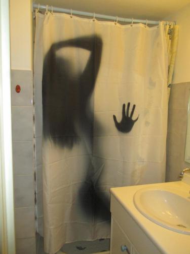 une personne dans un rideau de douche dans une salle de bain dans l'établissement Studio au calme à 5mn de la mer et de toutes attractions de la ville, à Cannes