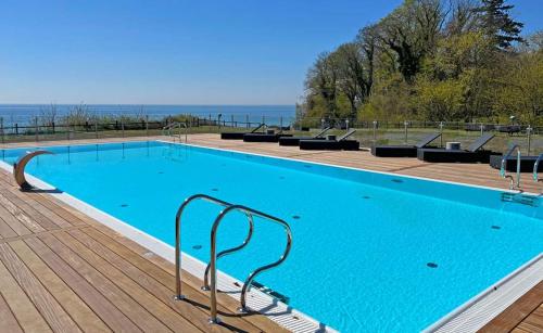 a large blue swimming pool on a wooden deck at Fredensborg Badehotel in Rønne