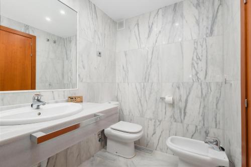 bagno bianco con lavandino e servizi igienici di Apartment, with indoor pool, jacuzzi, sauna and gym, in Benahavis a Estepona