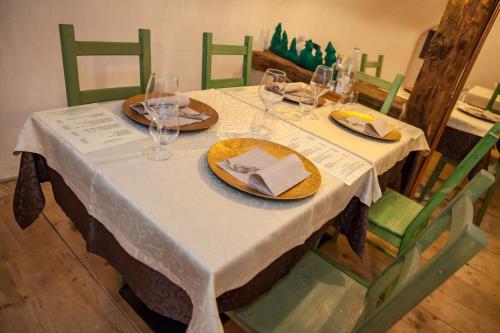 a table with wine glasses and plates on it at Hotel Garni Le Corti in Grosotto