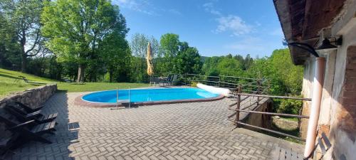 ein Schwimmbad in der Mitte eines Gartens in der Unterkunft Apartmány Javorek in Sněžné