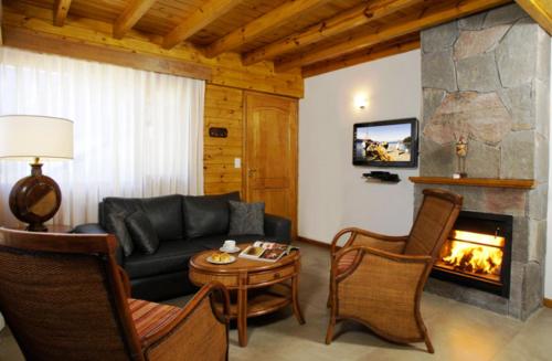 a living room with a couch and a fireplace at Apart Hotel Le Temps Des Cerises in San Martín de los Andes