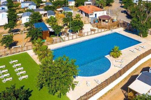 - une vue sur la grande piscine avec des chaises longues dans l'établissement MH135 camping TOHAPI NOVELA - Mobil home 5p climatisé -, à Port-la-Nouvelle
