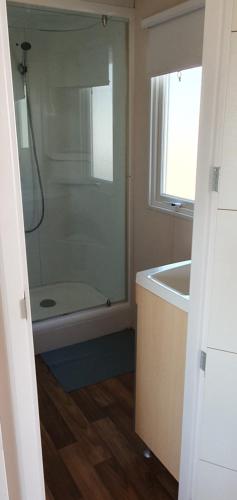 ein Badezimmer mit einer Dusche, einer Badewanne und einem Waschbecken in der Unterkunft MH135 camping TOHAPI NOVELA - Mobil home 5p climatisé - in Port-la-Nouvelle